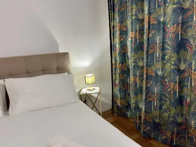 a bedroom with a bed with a tropical wallpaper at Trastevere alla Lungaretta, Rome in Rome