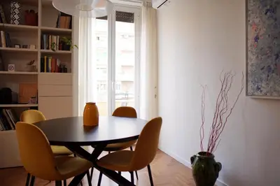 a dining room with a table and chairs and a window at Dolce Roma Apartment in Rome