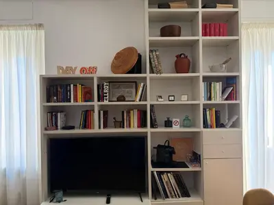 a white book shelf with a television in a living room at Dolce Roma Apartment in Rome