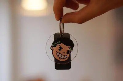 a hand holding a keychain with a face on it at Dolce Roma Apartment in Rome