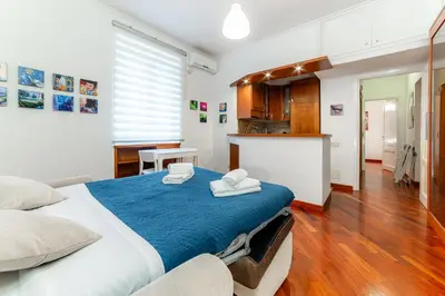 a bedroom with a large bed and a kitchen at Daniele Flat - Ospedale Gemelli - Metro Battistini in Rome