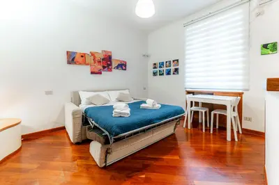 a bedroom with a bed with blue sheets and a table at Daniele Flat - Ospedale Gemelli - Metro Battistini in Rome