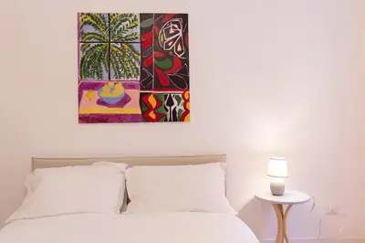 a bedroom with a bed with a painting above it at Appartamento Piazza Bologna - very well connected to Colosseum and station in Rome