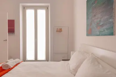 a white bedroom with a bed with white sheets at Appartamento Piazza Bologna - very well connected to Colosseum and station in Rome