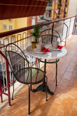 a table with two cups and chairs on a balcony at La casa di Gegè Appio Caffarella in Rome