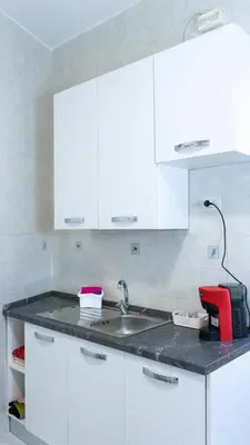 a kitchen with white cabinets and a sink at Casa Noemi in Rome