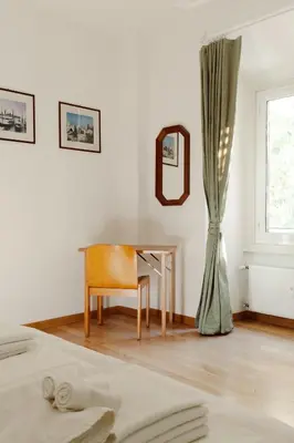 a bedroom with a table and a mirror and a window at Happy Home in Rome