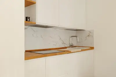a kitchen with white cabinets and a sink at Happy Home in Rome