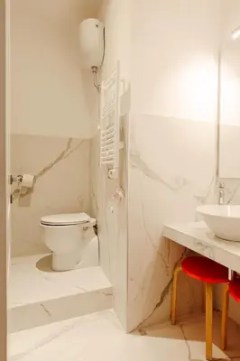 a white bathroom with a toilet and a sink at Happy Home in Rome