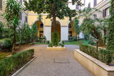a building with a palm tree in the middle of a street at Happy Home in Rome
