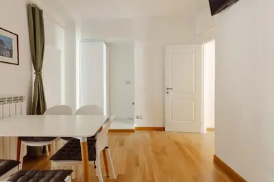 a white dining room with a white table and chairs at Happy Home in Rome
