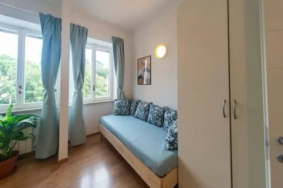 a living room with a couch and windows at 4 Cantoni, cosy apartment in Monti District in Rome