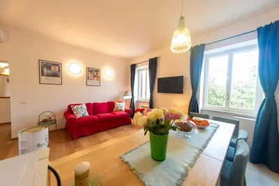 a living room with a red couch and a table with flowers at 4 Cantoni, cosy apartment in Monti District in Rome