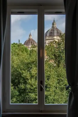 a window with a view of two domes at 4 Cantoni, cosy apartment in Monti District in Rome