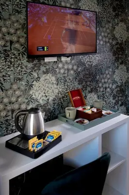 a table with a tv on a wall with a table with food at Guest House VB Luxury Suites in Rome