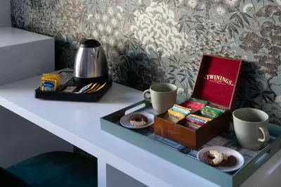 a table with a box of muffins and coffee cups at Guest House VB Luxury Suites in Rome