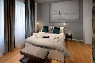 a hotel room with a large bed and a table at Guest House VB Luxury Suites in Rome
