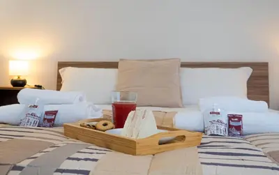 a tray of food and a drink on a bed at Aunt's Vatican Home in Rome