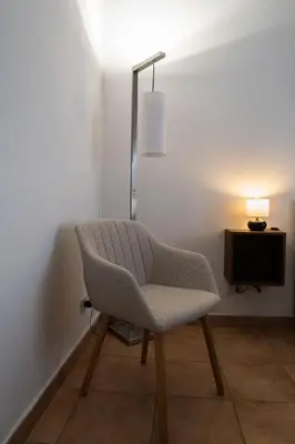 a chair in a room with a lamp and a television at Aunt's Vatican Home in Rome