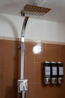 a metal shower in a bathroom with a wall at Aunt's Vatican Home in Rome