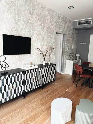 a living room with a tv on a wall at Twentythree Luxury Apartment in Rome