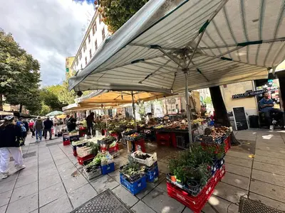a market with a large umbrella and people walking on a sidewalk at Bright House appartamento Roma in Rome