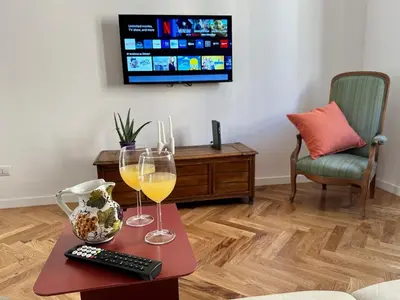 a living room with two glasses of wine and a remote control at Bright House appartamento Roma in Rome
