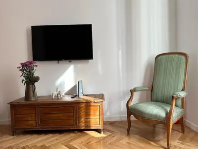 a living room with a chair and a tv on a wall at Bright House appartamento Roma in Rome