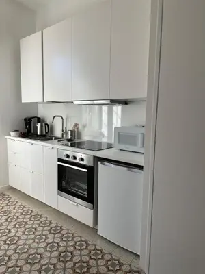 a kitchen with white cabinets and a stove top oven at Bright House appartamento Roma in Rome