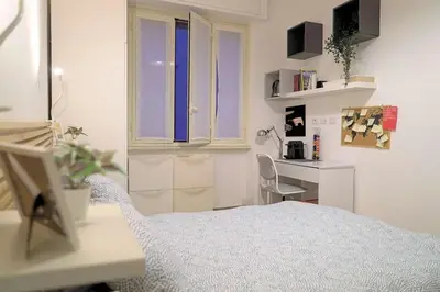 a white room with a bed and a desk at Room Etruria Center Rome in Rome