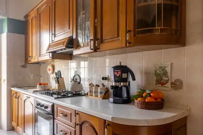 a kitchen with wooden cabinets and a counter top with oranges at The Magic of San Peter in the Heart of Rome in Rome