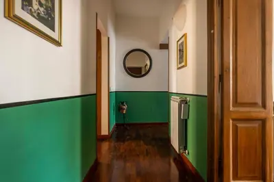 a hallway with green and white walls and a door at The Magic of San Peter in the Heart of Rome in Rome