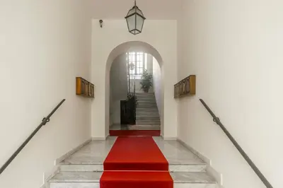 a hallway with a red carpet and stairs at The Magic of San Peter in the Heart of Rome in Rome