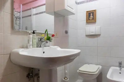 a white bathroom with a sink and a toilet at The Magic of San Peter in the Heart of Rome in Rome