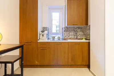 a kitchen with wooden cabinets and a window at Vatican Cipro Guest House in Rome