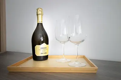 a bottle of wine and two wine glasses on a wooden tray at Vatican Cipro Guest House in Rome