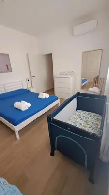 a bedroom with a blue bed and a chair at DimorAlexis, the house in front of Vatican's walls in Rome