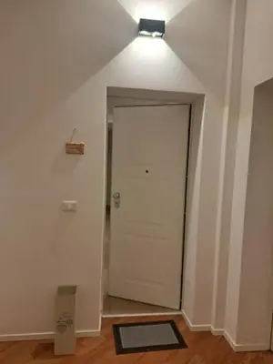 a hallway with a white door and a light at DimorAlexis, the house in front of Vatican's walls in Rome