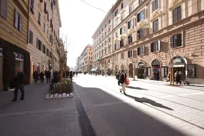a person walking down a city street with buildings at Ottaviano 2BR Holiday House in Rome