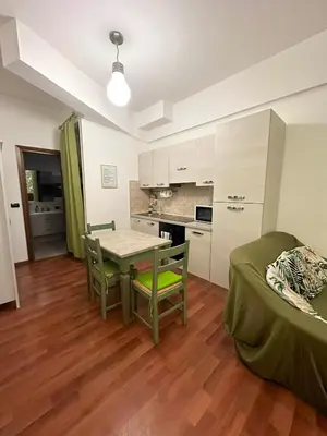 a room with a table and chairs and a kitchen at Cute apartment next to vatican in Rome