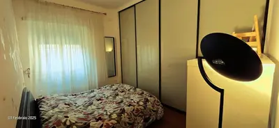 a bedroom with a bed and a hat on a lamp at L'Oasi di Monteverde - grazioso e collegatissimo in Rome