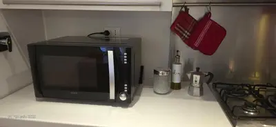 a microwave sitting on a counter next to a stove at L'Oasi di Monteverde - grazioso e collegatissimo in Rome