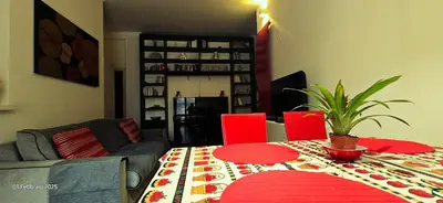 a living room with a table and red chairs at L'Oasi di Monteverde - grazioso e collegatissimo in Rome