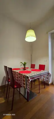a dining room table with red chairs and a lamp at L'Oasi di Monteverde - grazioso e collegatissimo in Rome