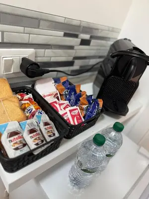 a refrigerator with snacks and water bottles on a shelf at Piignetoo Apartment in Rome