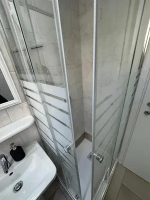 a shower with a glass door next to a sink at Piignetoo Apartment in Rome