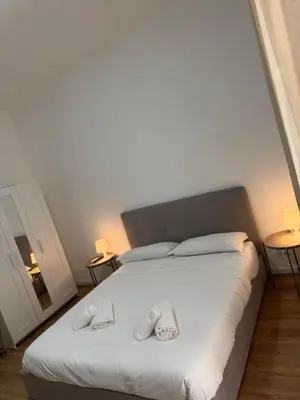 a bedroom with a bed with two slippers on it at Piignetoo Apartment in Rome