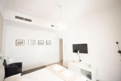 a white living room with a tv and a couch at Saint Peter Beautiful 2BR Apartment in Rome