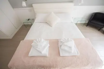 a bedroom with a white bed with two white towels at Saint Peter Beautiful 2BR Apartment in Rome