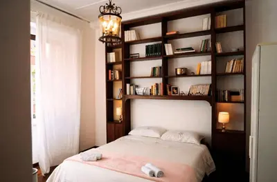 a bedroom with a bed and a book shelf at 10 Min Città del Vaticano-Stadio olimpico Lucia Apartment 1BDR in Rome